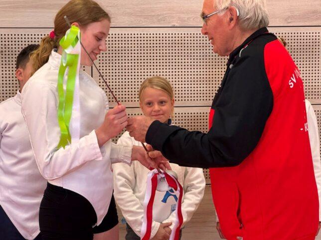 Frieda Junker erhält von Dieter Gawrisch ein Wettkampfflorett mit der Widmung der Trainer.